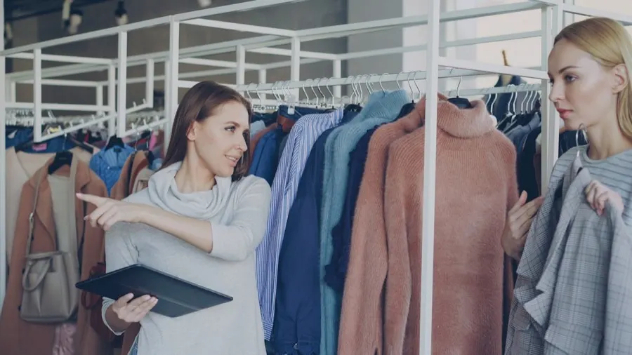 A retail assistant helping a customer choose clothing