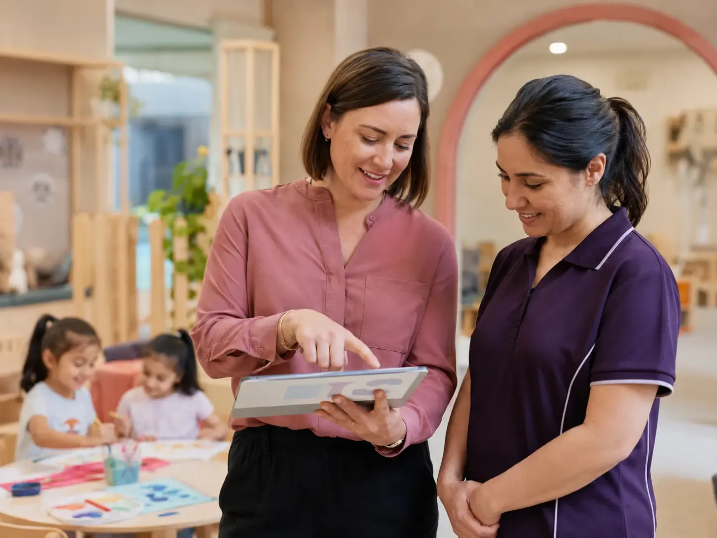 A centre director and an educator looking at the week together on a tablet