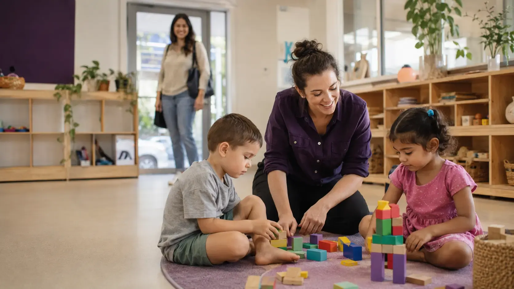 An educator supporting children at play in a warm early learning room