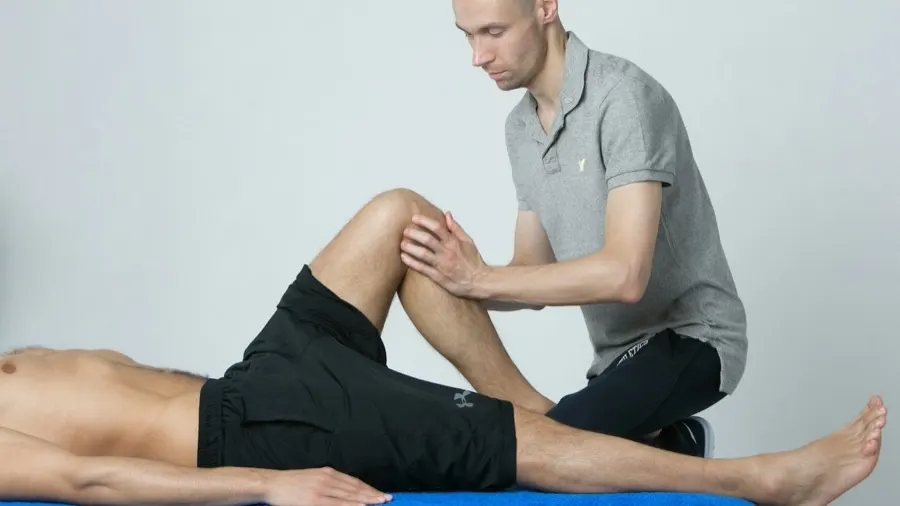 A physiotherapist treating a patient's knee on the table