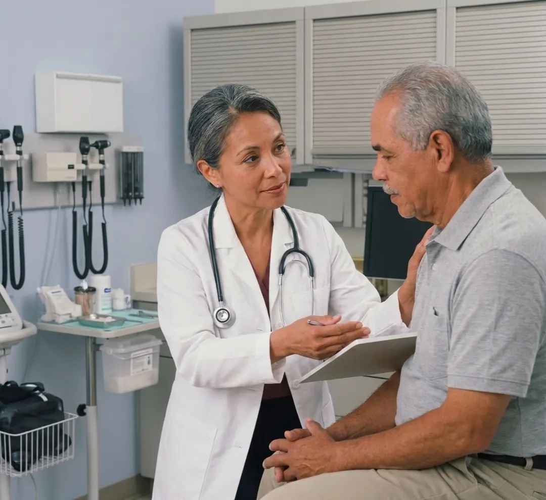 A GP talking an older patient through his results in a consult room